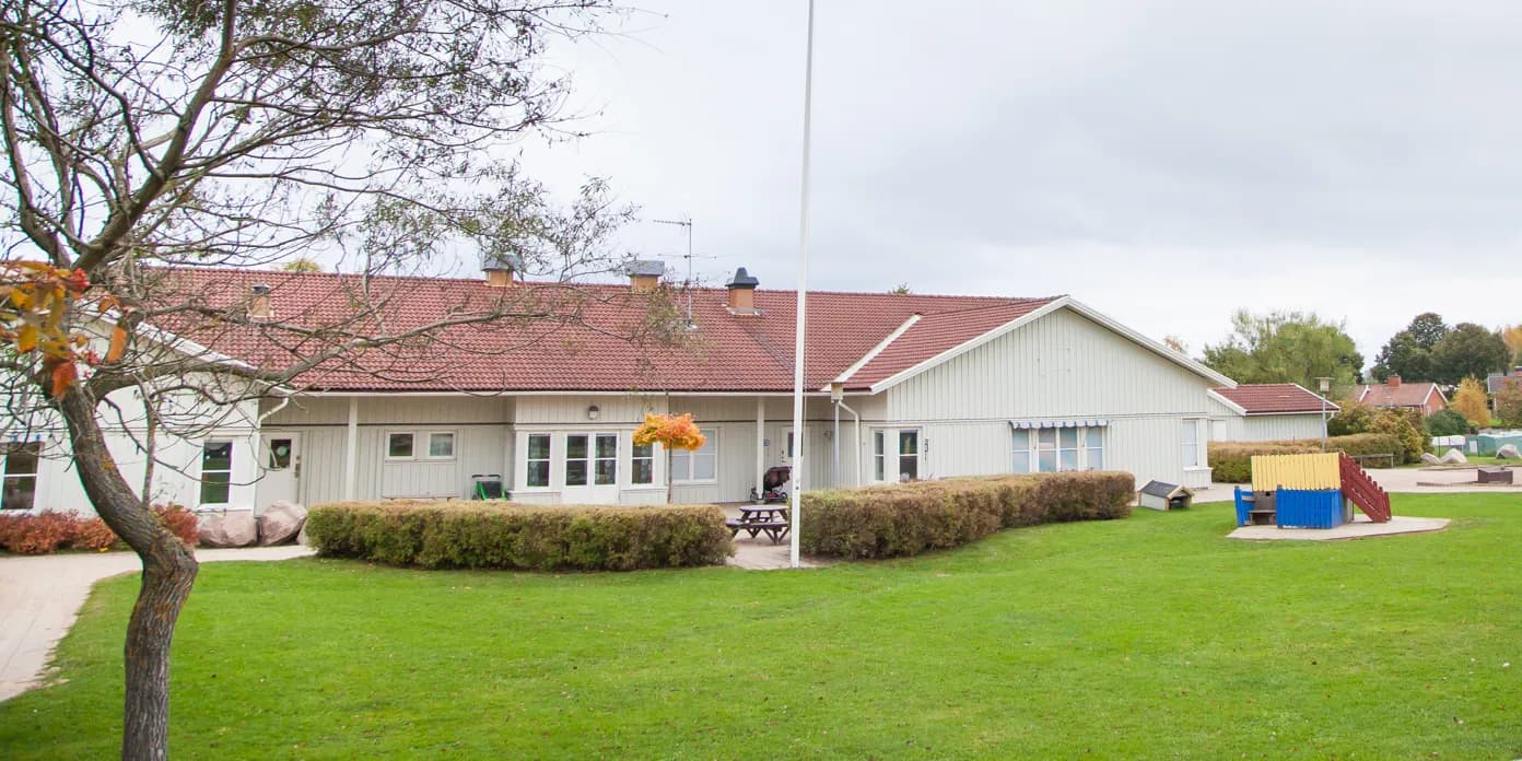 En stor trädgård med ett picknickbord och picknickbänkar