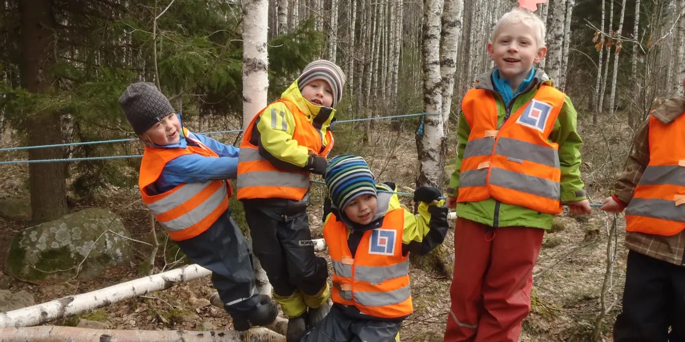 En grupp unga pojkar står på toppen av ett nedfallet träd