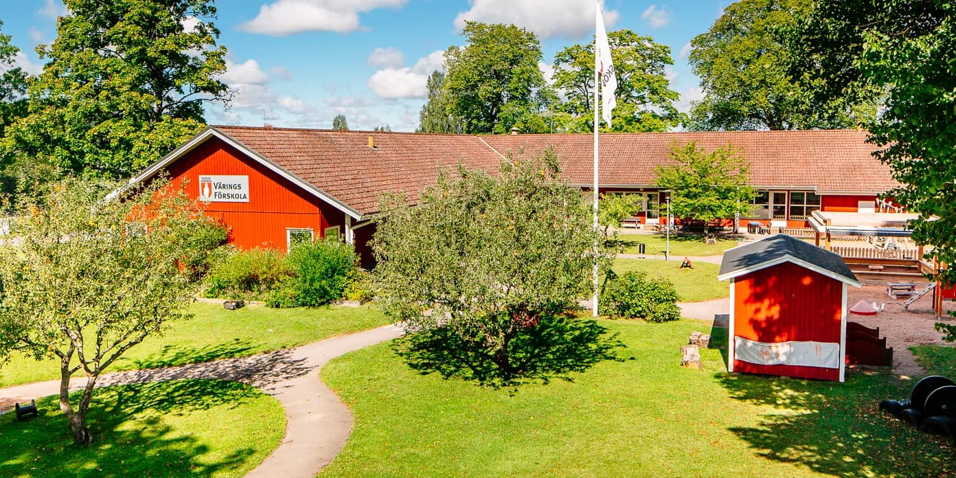 En röd lada bredvid ett grönskande fält