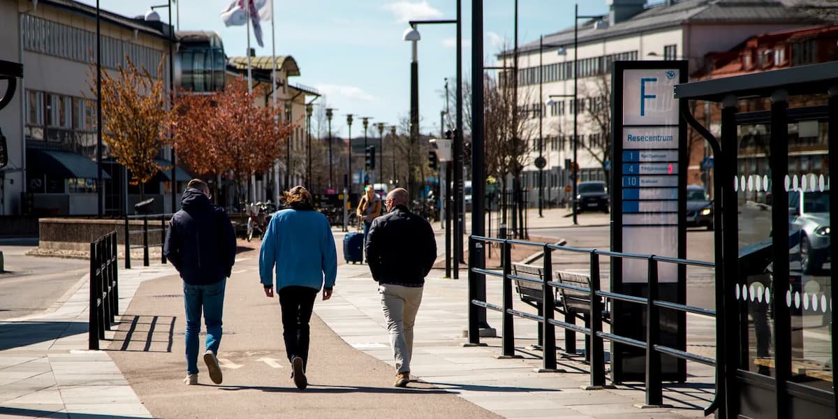 En grupp människor som går längs en trottoar